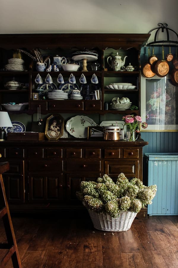 Blue and white dishes and antique copper pots styled in a kitchen for a timeless, collected interior