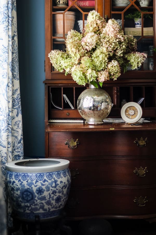 Secondhand furniture styled with layered books, ceramics, and warm textures.